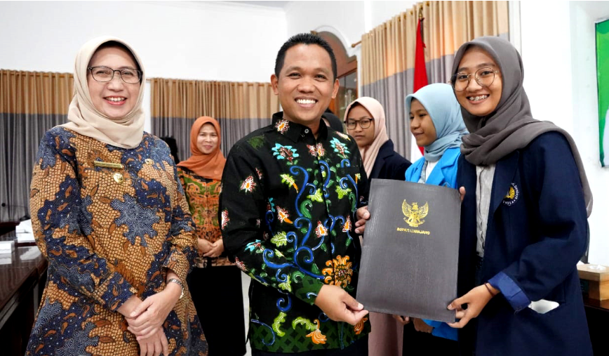 Bupati Lumajang Thoriqul Haq dan Wabup Indah Amperawati menyerahkan beasiswa pada penerima manfaat. (foto: Kominfo Lumajang)