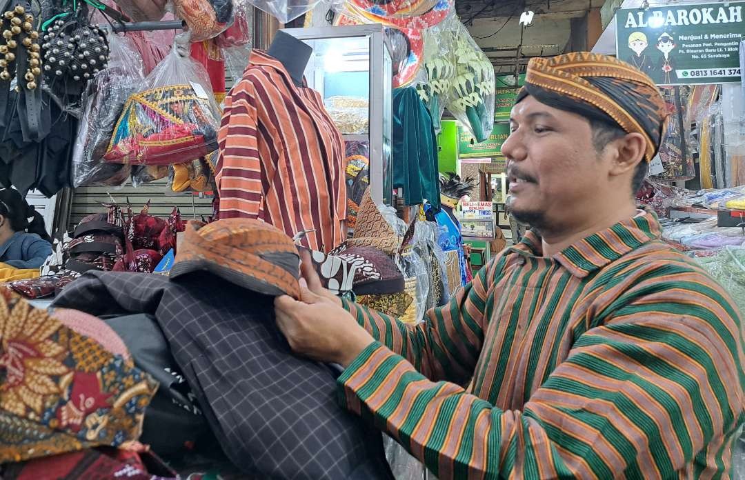 Kriswanto saat berbelanja baju lurik untuk upacara esok hari di Pasar Blauran, Surabaya. (Foto: Pita Sari/Ngopibareng.id)
