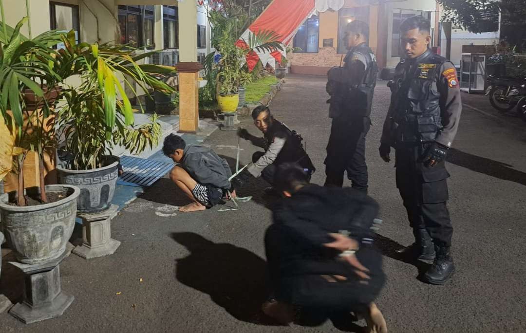 Polisi saat menangkap dua pemuda bersenjata tajam di kawasan Dharmahusada, Surabaya. (Foto: Ist)