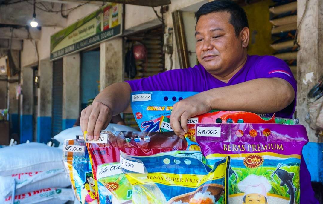 Pedagang beras di pasar larangan saat menata beras kemasan 5 kilogram di lapak (Foto: Aini/Ngopibareng.id)