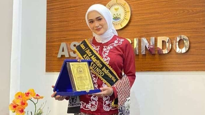 Harum Rizki Amalia menunjukkan plakat juara 1 Duta Maritim 2023. (Foto: Dokumentasi Humas Unej)