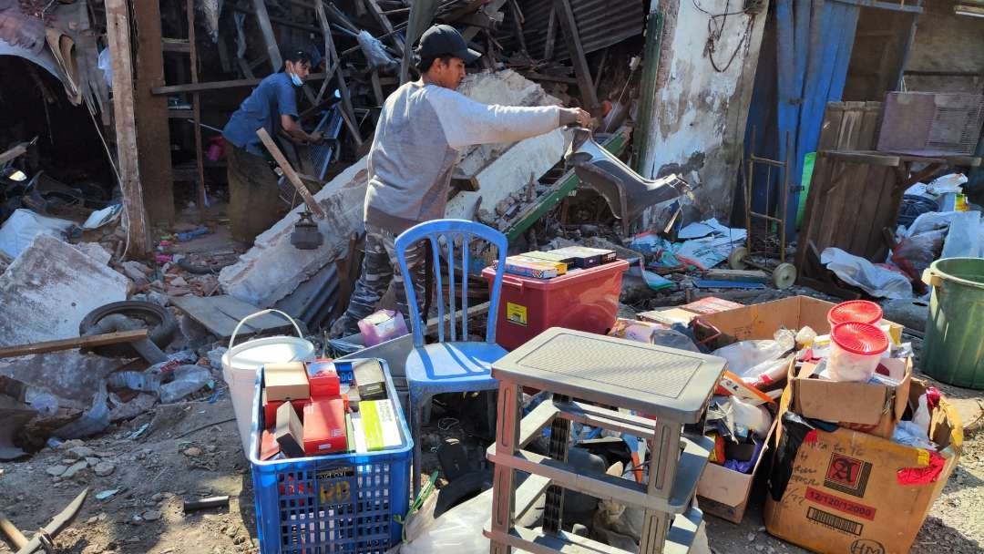 Pemilik toko melakukan evakuasi terhadap barang-barang yang bisa diselamatkan pasca bangunan ambruk, Selasa 5 September 2023. (Foto: Fariz Yarbo/Ngopibareng.id)