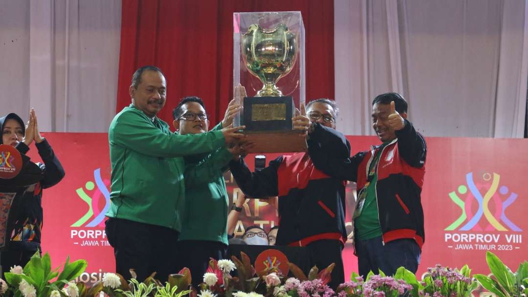 Sekdaprov Jatim, Adhy Karyono dan Ketua KONI Jatim M Nabil, menyerahkan trofi Juara Umum Porprov 2023 kepada Kota Surabaya, Sabtu 16 September 2023. (Foto: Fariz Yarbo/Ngopibareng.id)