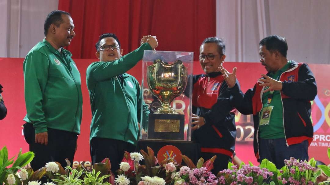 Sekdaprov Jatim, Adhy Karyono dan Ketua KONI Jatim, M Nabil, menyerahkan trofi Juara Umum Porprov 2023 kepada Kota Surabaya, Sabtu 16 September 2023. (Foto: Fariz Yarbo/Ngopibareng.id)