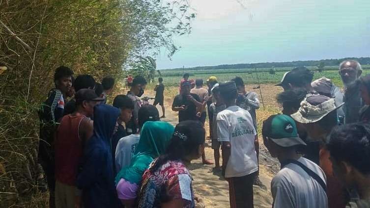 Warga mengerubuti mayat tergeletak di jalan setapak di Desa Pesisir, Kecamatan Sumberasih, Kabupaten Probolinggo. (Foto: Ikhsan Mahmudi/Ngopibareng.id)