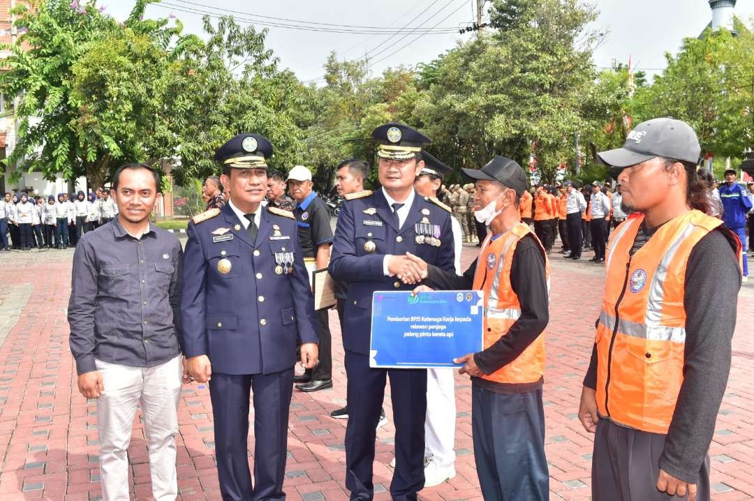 Bupati Lamongan, Yuhronur Efendi menyerahkan penghargaan kepada penjaga palang pintu perlintasan kereta api. (Foto: Istimewa)