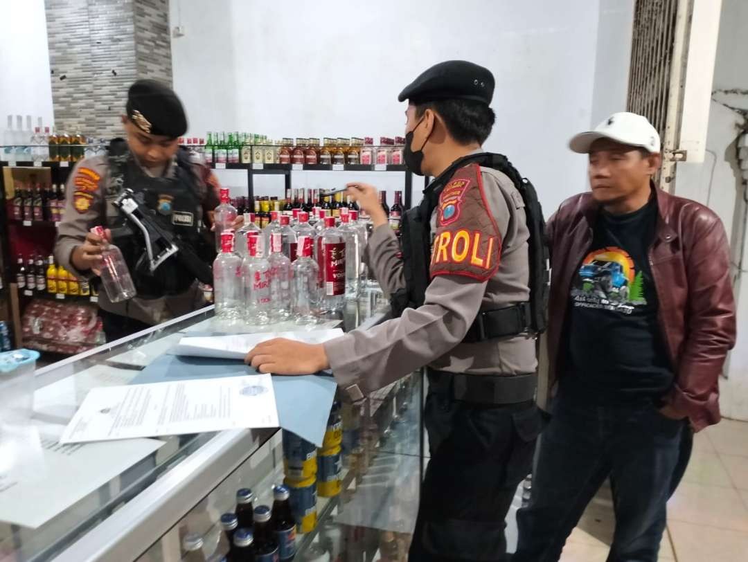 Polisi saat menyita minuman keras di dalam toko yang berada di Jalan Sumatera, Sumbersari, Jember (Foto: Istimewa)