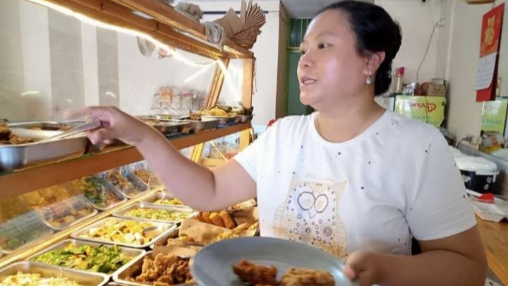 Maria pengelola kedai Vege, khusus masakan vegetarian sibuk melayani pelanggan. (Foto: Asmanu Sudharso/Ngopibareng.id)