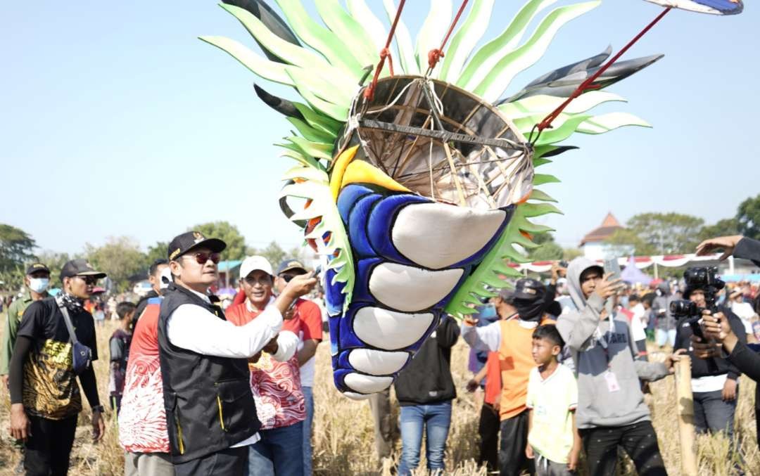 Bupati Lamongan Yuhronur Efendi saat mencoba menaikkan layang-layang naga di festival yang digelar di Desa/Kecamatan Laren. (Foto: Istimewa)