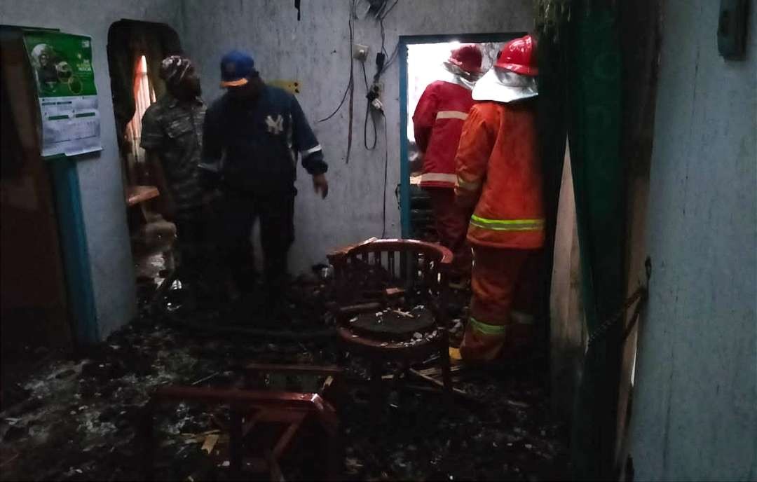 Petugas pemadam kebakaran mengecek bagian dalam rumah yang terbakar untuk memastikan tidak ada titik api lagi (foto:Istimewa)