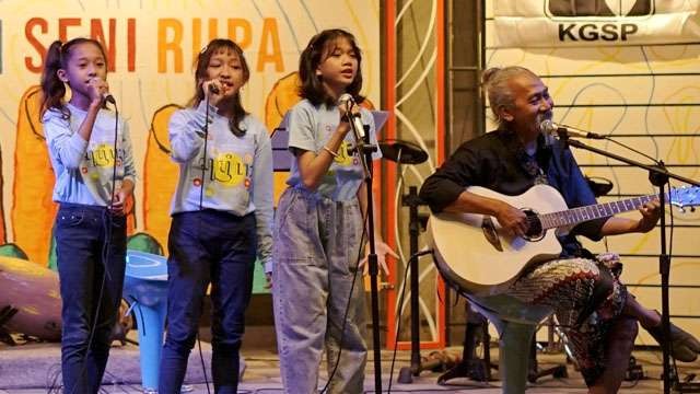 Tiga orang anak didik Sanggar Petelot-Konte diiringi Gatot Japet sedang menyanyikan lagu-lagu Leo Kristi pada pembukaan Pameran ‘Salam Hangat’ di K-Naya Artspace, Pasuruan. (Foto:Ngopibareng.Id/WN)