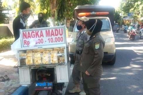 Seorang pedagang buah keliling di Jalan Suroyo ditertibkan Satpol PP Kota Probolinggo. (Foto: Ikhsan Mahmudi/Ngopibareng.id)