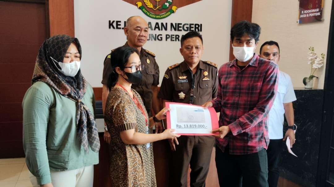 Korban jurnalis Nurhadi menerima pembayaran restitusi oleh keluarga dua terpidana di Kejari Tanjung Perak, Surabaya, Rabu 4 Oktober 2023. (Foto: Fariz Yarbo/Ngopibareng.id)