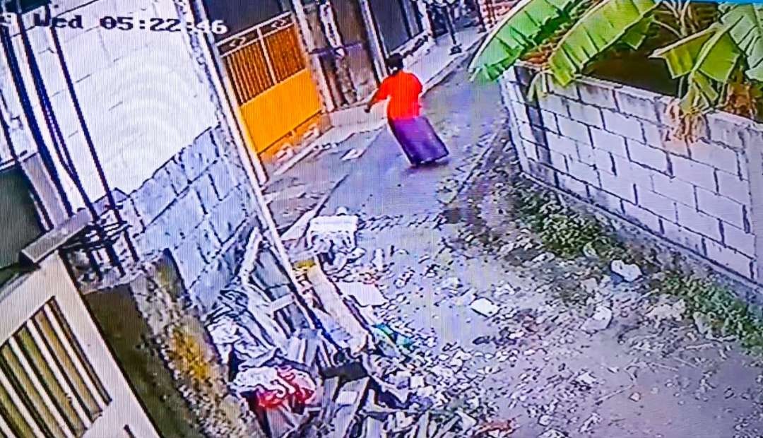 Tangkapan layar CCTV Masriah berjoget usai teror buatan in sampah di jalan depan rumah Wiwik (foto : Aini/Ngopibareng.id)
