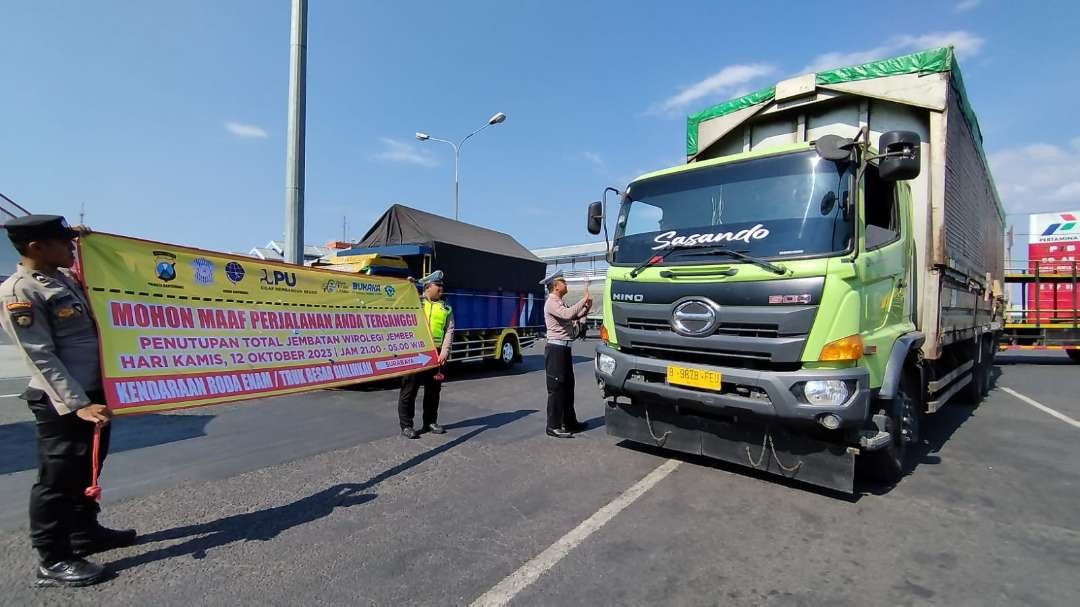 Polisi melakukan sosialisasi kepada sopir truk di pintu keluar Pelabuhan Ketapang, Banyuwangi (foto: Muh Hujaini/Ngopibareng.id)