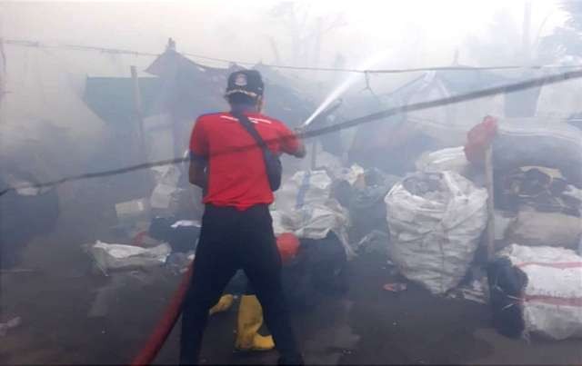 Anggota Damkar Situbondo terus melakukan proses pembasahan tumpukan sampah TPA Sliwung Situbondo yang terbakar. (Foto: DLH Situbondo)