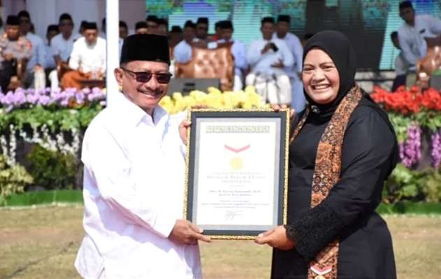 Bupati Situbondo Karna Suswandi menerima penghargaan Rekor MURI atas santri peserta terbanyak se-Indonesia Apel Hari Santri Nasional 2023.(Foto: Diskominfo Situbondo)