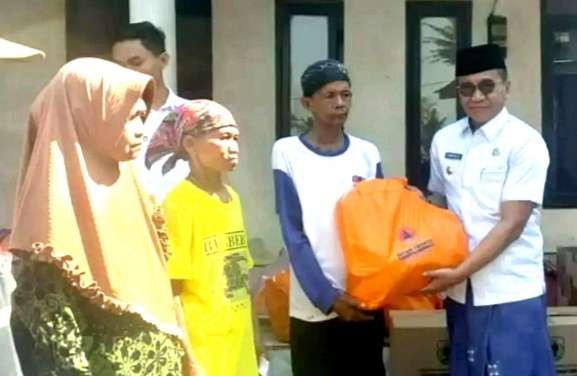 Pj Bupati Bondowoso Bambang Soekwanto menyerahkan bantuan sembako dari pemkab kepada warga korban puting beliung di Kecamatan Maesan.(Foto:Guido/ngopibareng.id)