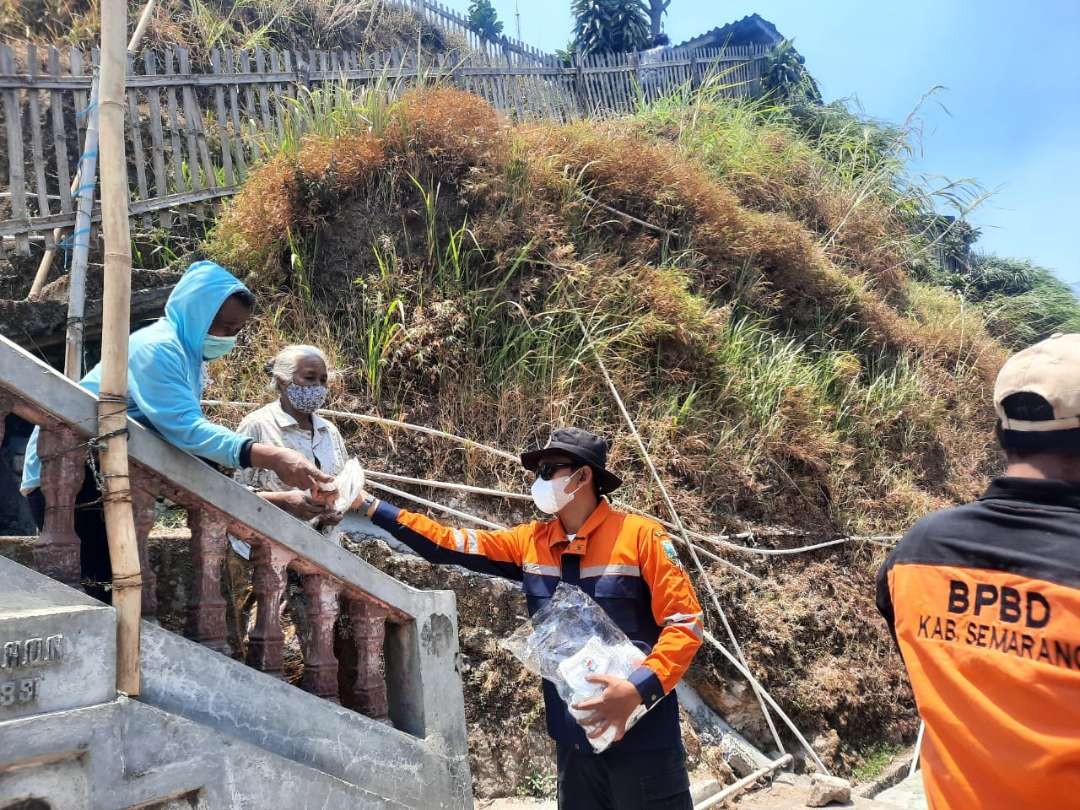 Petugas dari BPBD Kabupaten Semarang membagikan masker kepada warga Desa Ngaduman yang terdampak asap kebakaran lahan dan hutan Gunung Merbabu, Sabtu 28 Oktober 2023.(Foto: BPBD Kabupaten Semarang)