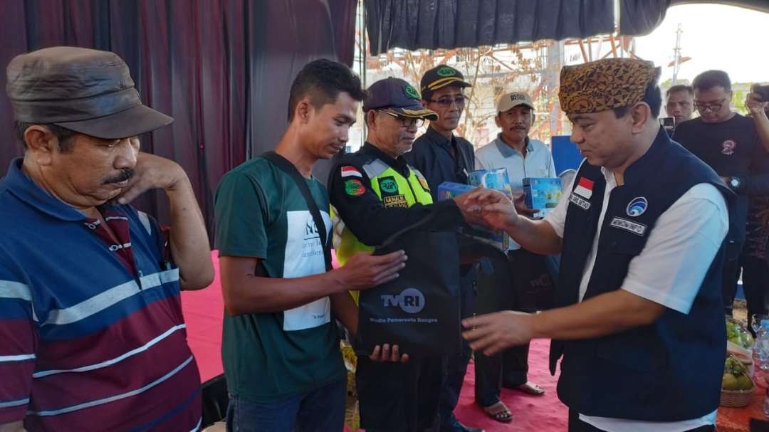 Menkominfo Budi Arie Setiadi menyerahkan STB kepada masyarakat, agar bisa menikmati siaran TV digital. (Foto: Muh Hujaini/Ngopibareng.id)