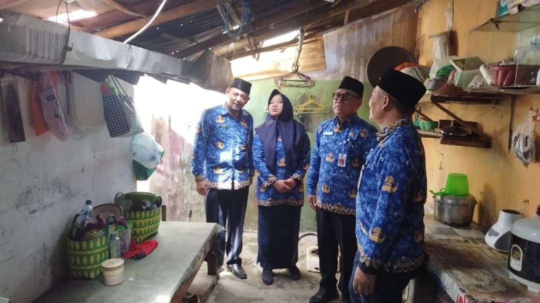 Sekretaris Daerah Mujiono bersama sejumlah Kepala SKPD melihat kondisi rumah Edi Purnomo sebelum dibedah (foto: Muh Hujaini/Ngopibareng.id)