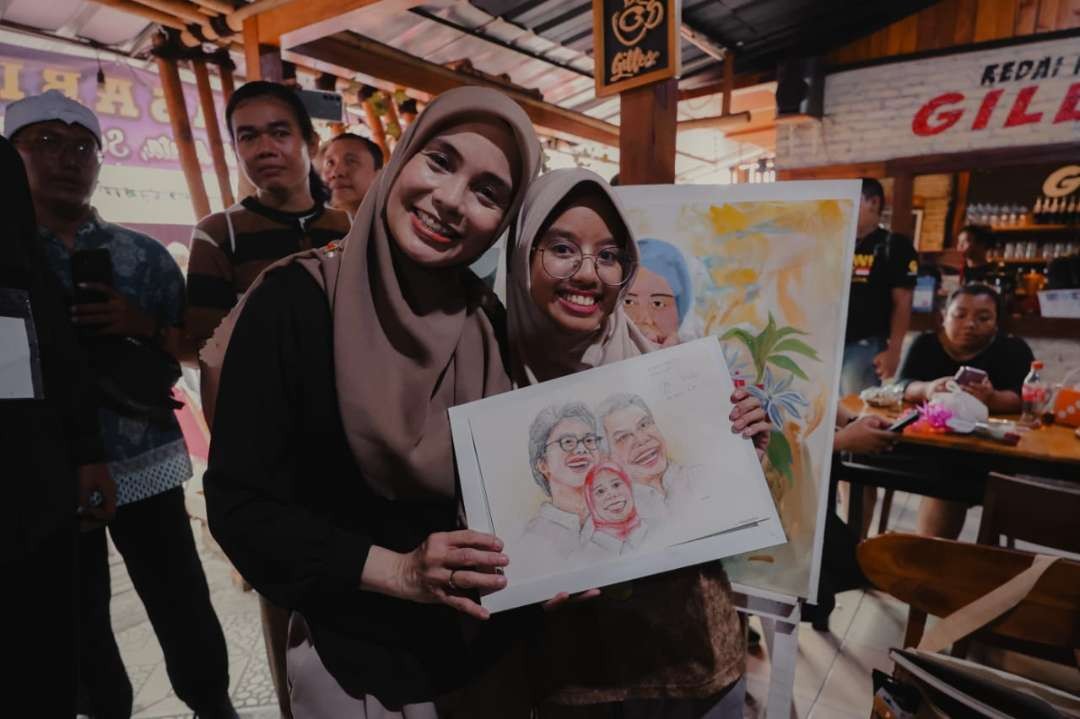 Siti Atikoh, istri capres Ganjar Pranowo, menerima lukisan hasil karya Nayla saat perayaan Hari Disabilitas Internasional, Minggu 3 Desember 2023. (Foto: Istimewa)