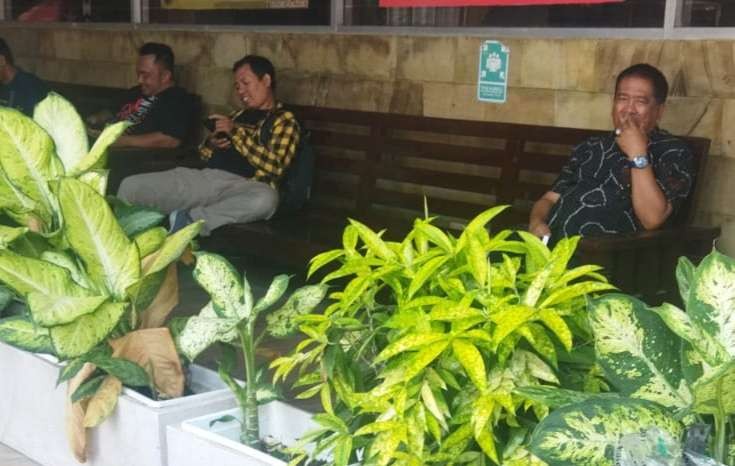 Kadis BSBK Bondowoso, Munandar duduk di kursi depan ruangan Satreskrim Polres Jember, menjalani pemeriksaan KPK. (Foto: Istimewa)