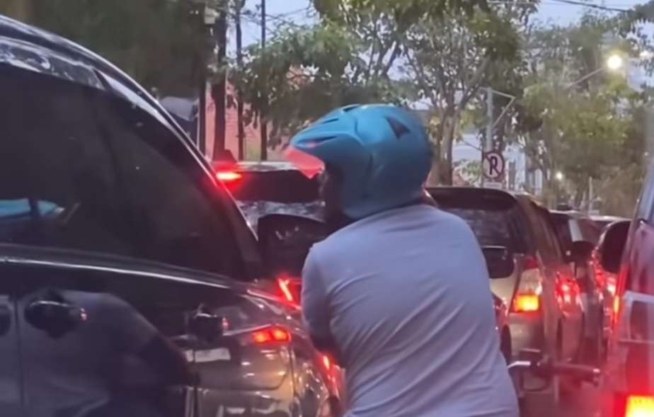 Seorang pengendara motor yang melakukan aksi meminta uang kepada pengendara mobil dengan mengetuk kaca mobil viral di media sosial. (Foto: Tangkapan Layar Instagram)