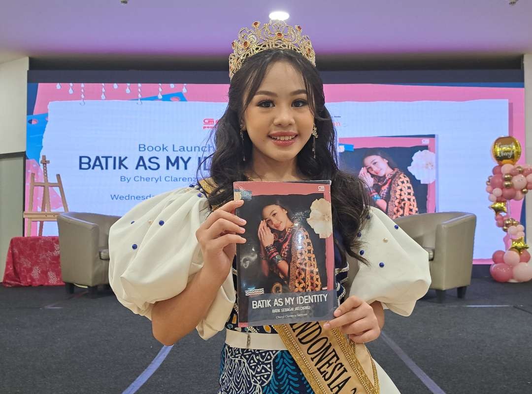 Putri Batik Cilik Indonesia 2023, Cheryl Clarenza Santoso saat menunjukan buku pertamanya berjudul 'BATIK AS MY IDENTITY'. (Foto: Pita Sari/Ngopibareng.id)
