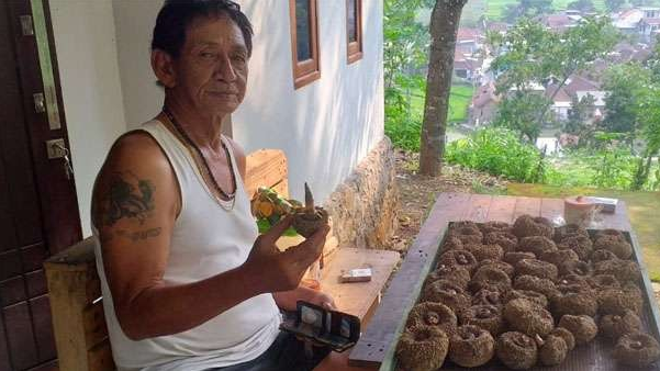 Harry Susanto dengan ubi porang di rumahnya di Duyung, Trawas Mojokerto. Bagi Petani Porang, Pemerintah Hanya PHP. (Foto: M. Anis/Ngopibareng.id)