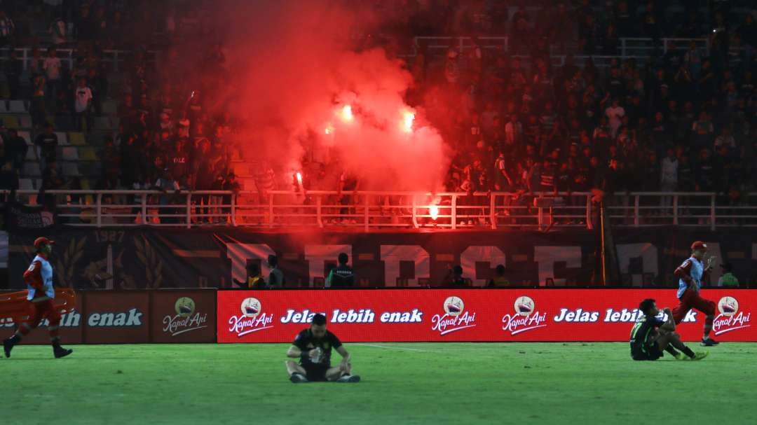 Suporter Bonek Mania menyalakan flare, usai laga Persebaya melawan Persis Solo. (Foto: Fariz Yarbo/Ngopibareng.id)
