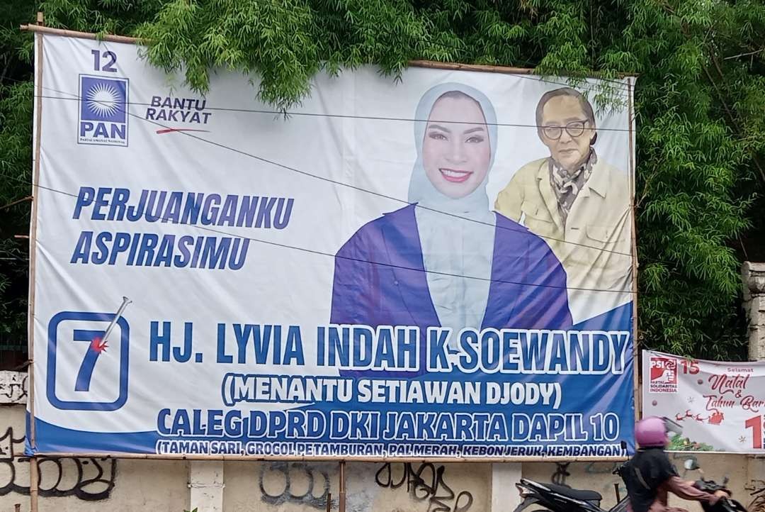 APK berupa baliho berukuran besar milik seorang Caleg DPRD DKI Jakarta, mencantumkan nama mertua (Foto: Asmanu Sudarso/ngopibareng.id)