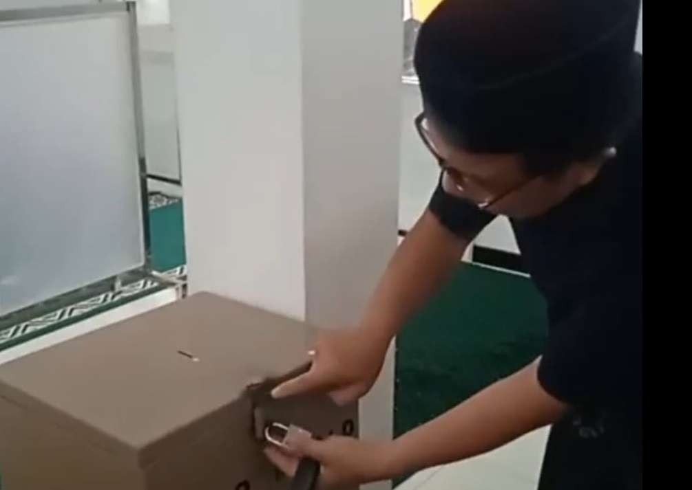 Ketua Takmir Masjid Zainal Arifin menunjukkan kotak amal yang sempat dibawa maling. (Foto: Istimewa)
