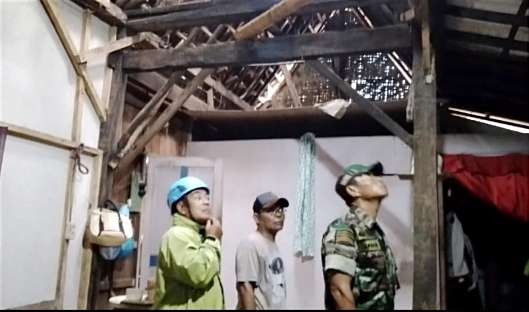 Anggota BPBD Situbondo dan TNI Kodim 0823 meninjau rumah kakek di Kecamatan Kendit rusak tertimpa pohon tumbang.(Foto: Dokumen BPBD Situbondo)