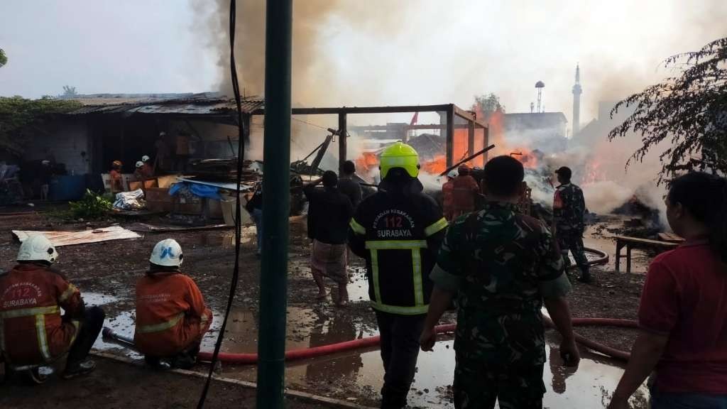 Petugas melakukan proses pemadaman kebakaran sebuah gudang kayu di Jalan Dupak Masigit, Surabaya, Senin 1 Januari 2023. (Foto: Istimewa)