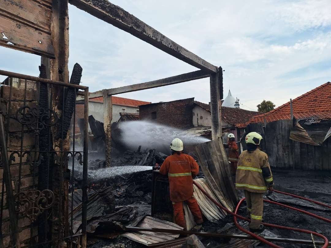 Petugas DPKP Surabaya melakukan pemadaman pada gudang pallet yang terbakar di kawasan Jepara, Bubutan, Surabaya. (Foto: Julianus Palermo/Ngopibareng.id)