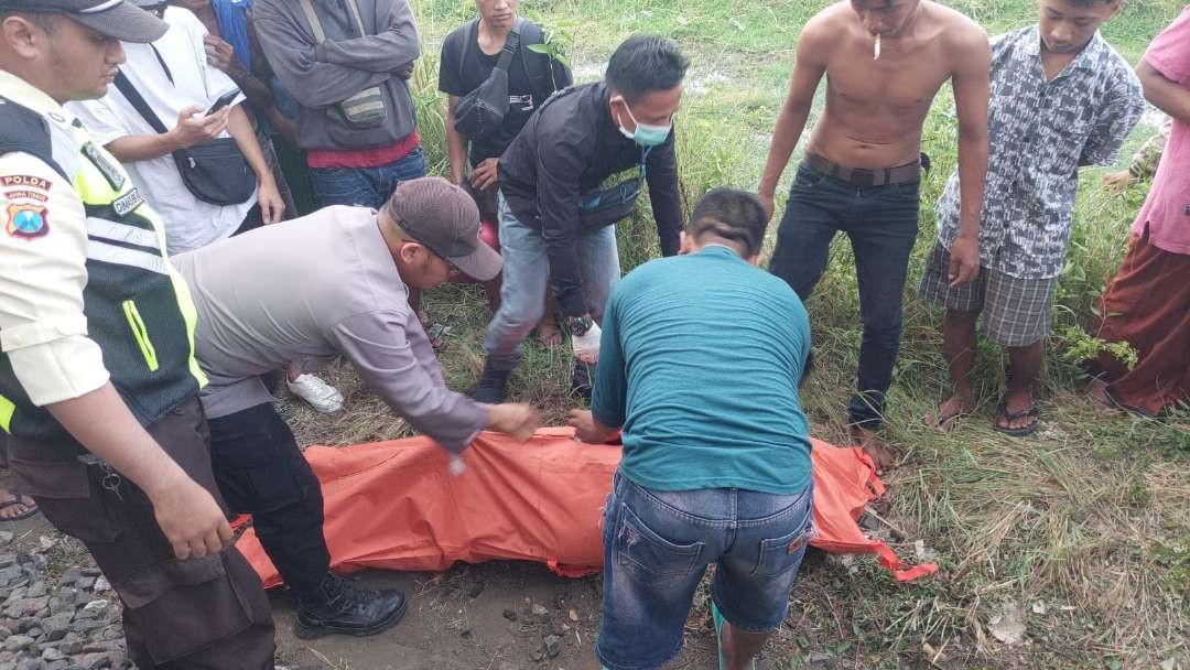 Polisi dan warga sekitar mengevakuasi jenazah korban tertabrak kereta api di Desa Banjarsasi, Kecamatan Sumberasih, Kabupaten Probolinggo. (Foto: Ikhsan Mahmudi/Ngopibareng.id)
