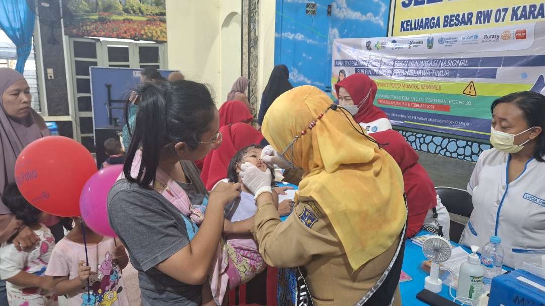 Lurah Kelurahan Mojo Suwarti saat meneteskan imunisasi kepada salah satu anak di Balai RW VII, Kelurahan Mojo, Surabaya, pada Senin 15 Januari 2024. (Foto: Julianus Palermo/Ngopibareng.id)