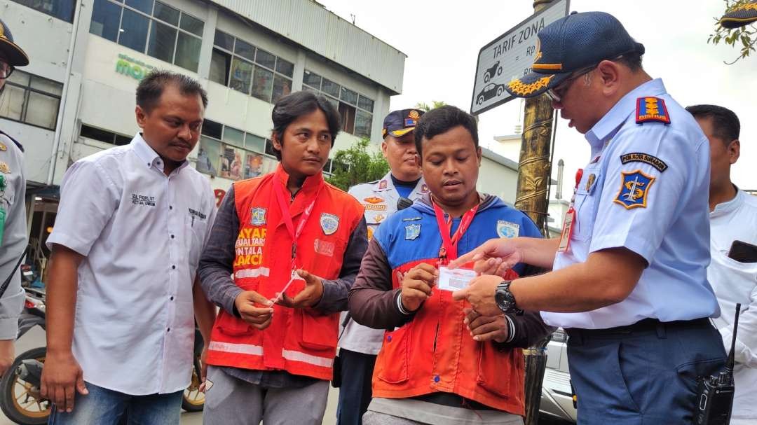 Kadishub Surabaya, Tundjung Iswandaru (kanan) saat menyerahkan barcode kepada Jukir di Jalan Tunjungan, Surabaya, Kamis 1 Februari 2024. (Foto: Fariz Yarbo/Ngopibareng.id)