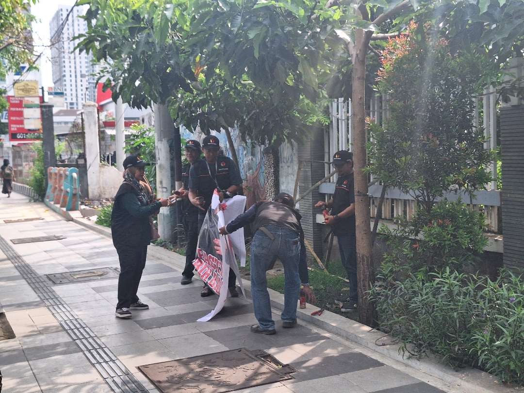 Potret petugas gabungan saat mengamankan APK yang melanggar di Jalan Jenderal Ahmad Yani, Gayungan, Surabaya. (Foto: Julianus Palermo/Ngopibareng.id)