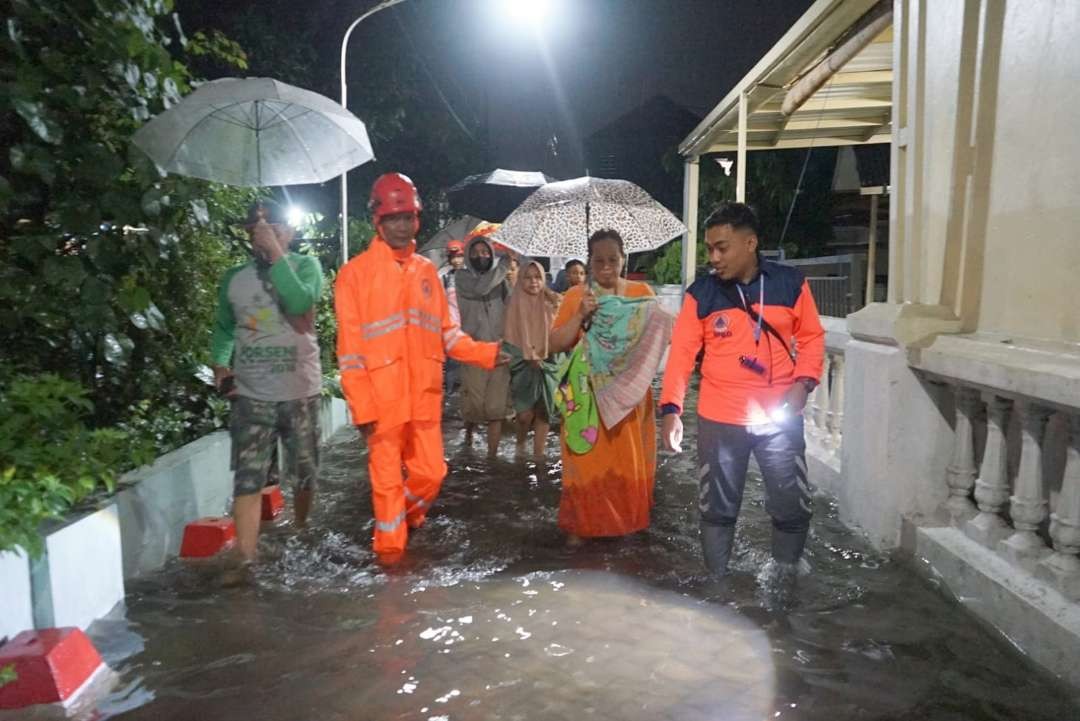 Petugas BPBD Jatim melakukan evakuasi warga terdampak banjir di Waru, Sidoarjo. (Foto: Istimewa)