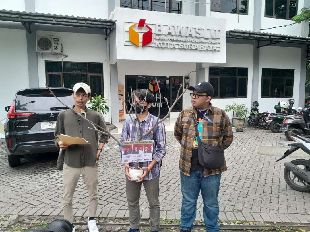 Perwakilan LBH Surabaya dan Walhi Jawa Timur saat memberi bingkisan berupa bangkai pohon kepada Bawaslu Kota Surabaya, Rabu 7 Februari 2024. (Foto: Julianus Palermo/Ngopibareng.id)