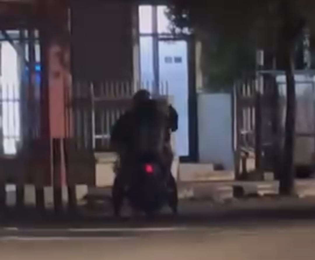 Pengendara motor berhenti di depan pos polisi kemudian menganiaya anak perempuannya. (Foto; tangkapan layar video di Instagram).