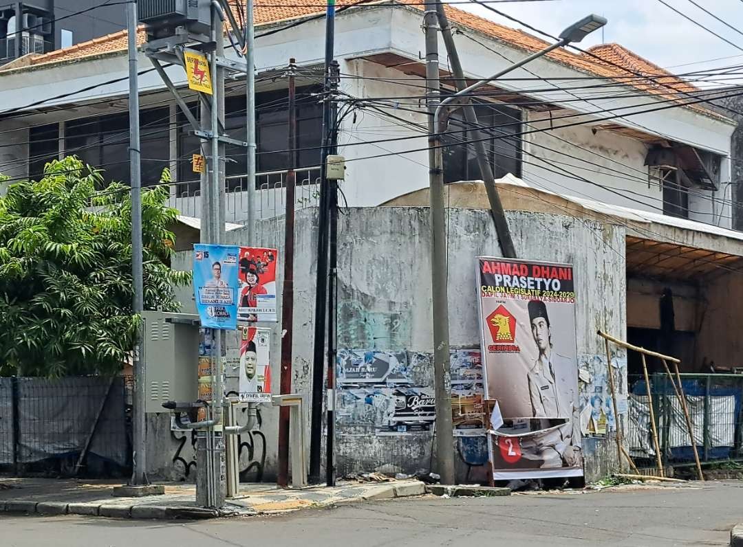 Sejumlah APK yang masih bertengar didepan gang saat masa tenang Pemilu 2024. (Foto: Pita Sari/Ngopibareng.id)