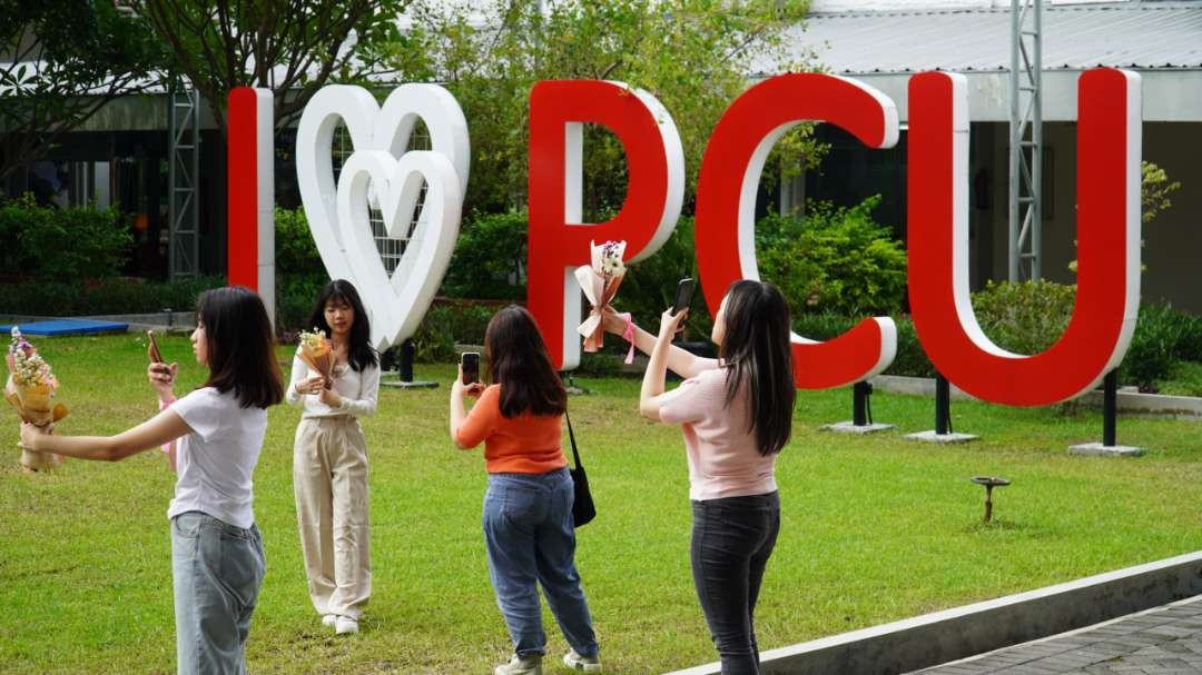 Beberapa mahasiswi PCU mengabadikan hasil karya merangkai bunganya di Kampus Utama PCU, Senin 12 Februari 2024. (Foto: Humas PCU)