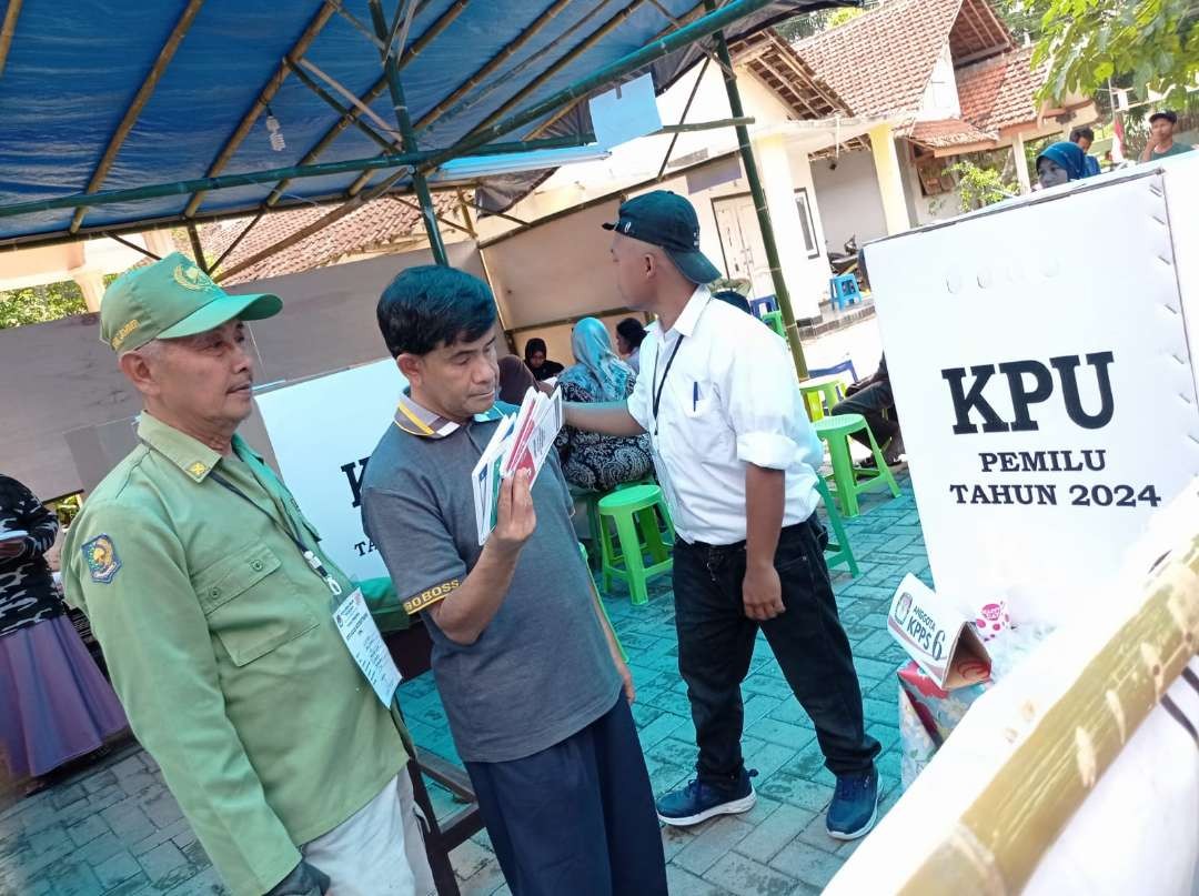 Ketua Ikatan Tunanetra Muslim Indonesia (ITMI) Cabang Jember, Rachman Hadi, hendak memasukkan surat suara yang sudah dicoblos. (Foto: Rusdi/Ngopibareng.id)