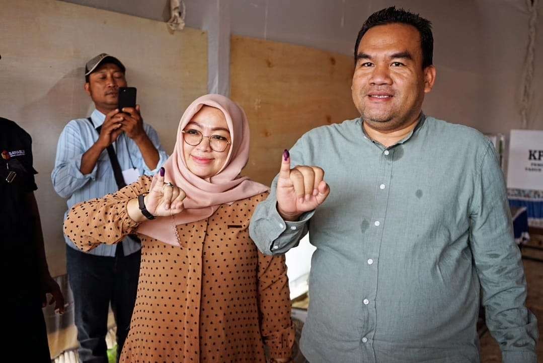 Bupati Blora Arief Rohman bersama Istrinya menunjukkan jari kelingking, usai nyoblos. (Foto: Sampurno/ngopibareng.id)