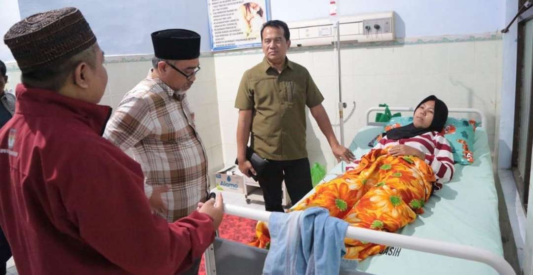 Pj Walikota Nurkhololis (paling kanan, berdiri) didampingi Ketua KPU, Ahmad Hudri menjenguk anggota KPPS yang sakit di RSUD. (Foto: Diskominfo)
