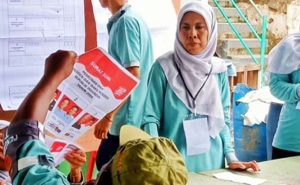 Seorang petugas KPPS menerawang surat susra yang sudah dicoblos. (Foto: Asmanu Sudharso/ngopibareng.id)