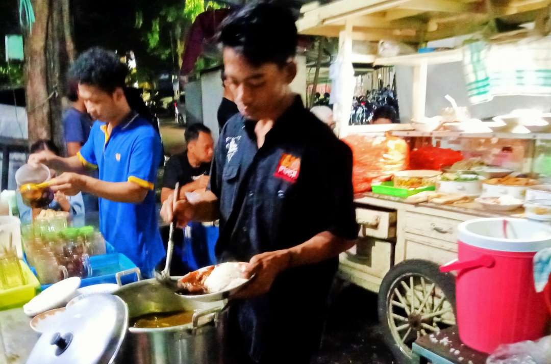 Karyawan warung  nasi pecel campur rawon Pasar Pucang bekerja ekstra, pembelinya membeludak. (Foto: Asmanu Sudharso/Ngopibareng.id)o